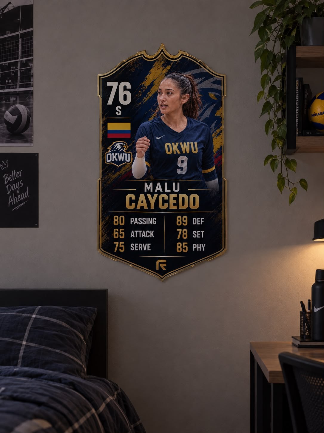 A close-up of Malu Caycedo's card mounted as a shield-shaped cutout on a bedroom wall